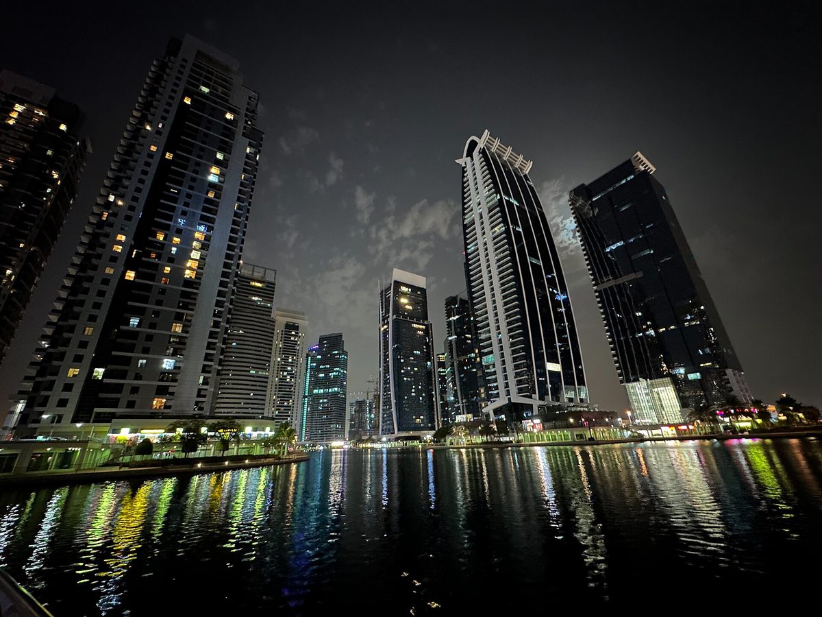 Jumeirah Lakes Towers lit up at night across the lake